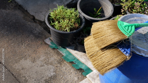 Cleaning Tools and Gardening Pots on a Sunlit Ground Surface for Outdoor Maintenance