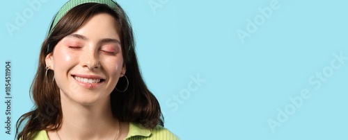 Tableau sur toile Happy young woman with face piercing on blue background with space for text