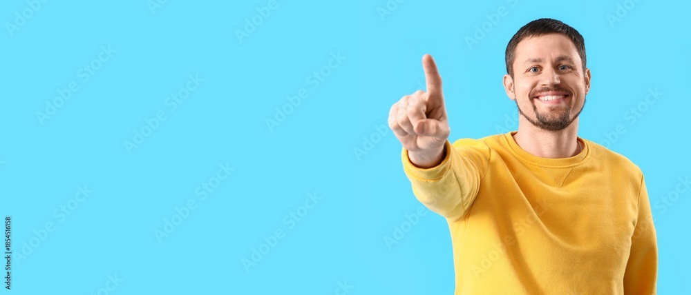 Naklejka premium Happy man using virtual screen on blue background. Banner for design