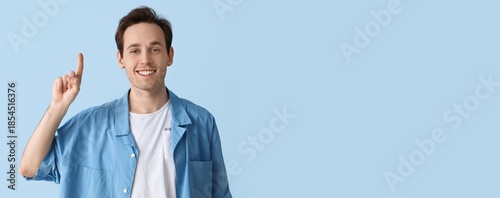 Young man pointing upward o...