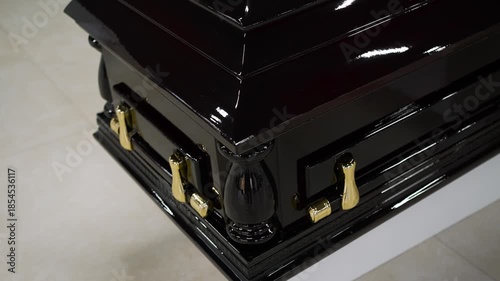 A gloomy dark-colored coffin with the deceased stands at the funeral service