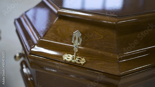 Chic wooden coffin covered with varnish in a funeral salon