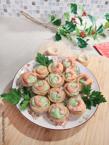 Cold appetizer for holiday table. Shortcrust pastry baskets with shrimp and cream cheese and spinach filling. Homemade healthy seafood.
