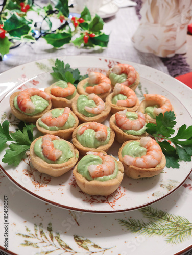 Cold appetizer for holiday table. Shortcrust pastry baskets with shrimp and cream cheese and spinach filling. Homemade healthy seafood.