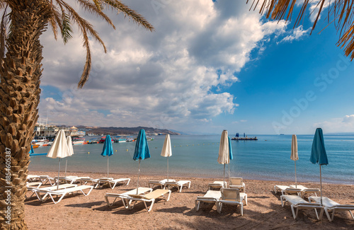 Sunny morning on sandy beach of the Red Sea in Eilat - famous tourist resort and recreational city in Israel