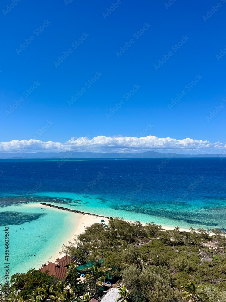 Obraz premium The view of a vibrant blue ocean and lively reef from the top of the Amédée Lighthouse on Amédée Islet, a remote, tropical island in New Caledonia, a French overseas territory in the South Pacific.