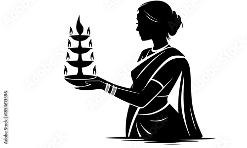 Silhouette of an Indian woman in a traditional saree holding a tiered ceremonial oil lamp or diya for Diwali, spiritual rituals, and cultural festival concepts.