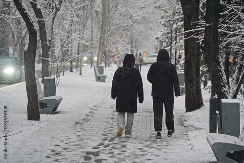 Almaty, Kazakhstan - 12.18.2025 : People are walking down the street in a heavy snowfall.