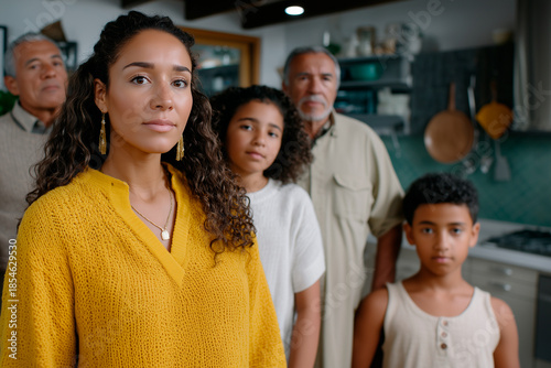 Multigenerational Latino family standing together seriously at home
