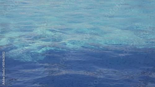 Gentle waves on a clear blue ocean surface.