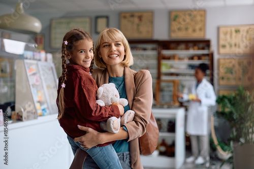 Happy mother and daughter in pharmacy.