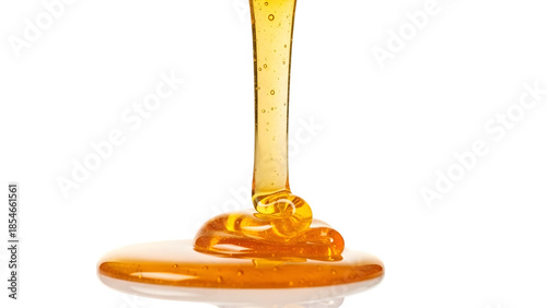 Golden honey pouring from a spoon onto a white surface with bubbles visible in the liquid isolated on a transparent background