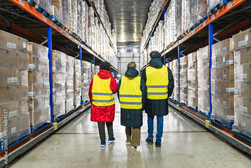 Fotografía Logistics workers in safety vests walking through a low temperature cold storage