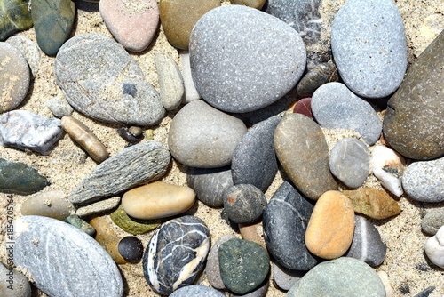 Fotografie pebbles in the sand on the beach. pebbles background.