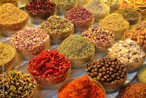 arabian spice and herb street market stall. Traditional spices market. Pots and wooden tubs stand in row with colorful tea, spices, fruits, roots, flowers. Street bazaar. Dubai, UAE.