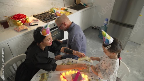 Birthday Party Kitchen Child Mother Candles Celebration: Family enjoys birthday cake in kitchen.