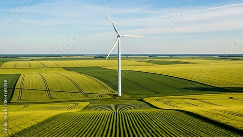 Wind turbine standing tall in vast green agricultural landscape