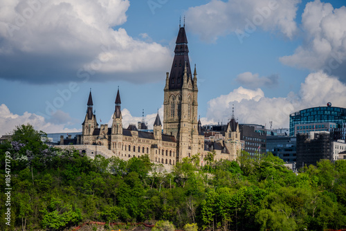 Canadian parliament buildings rising above trees under cloudy sky