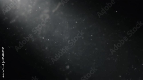 Atmospheric light beam illuminates floating dust particles creating abstract background.