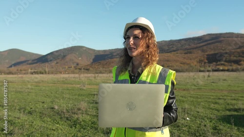 Professional Female Engineer Surveys Land Holding Laptop At Mountain Construction Site.