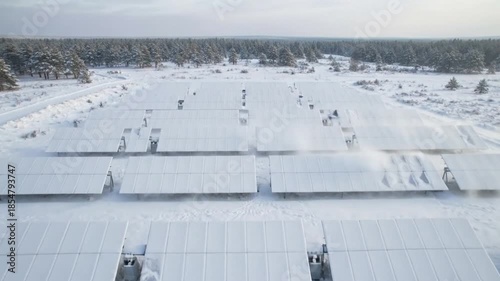 Snow-Covered Solar Panels with Morning Sunlight – Winter Renewable Energy Aerial View