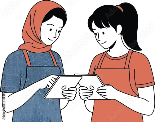 Two women in aprons looking at tablets