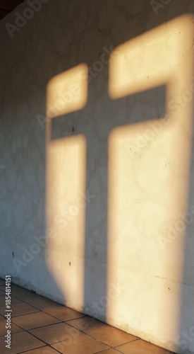 Shadow of a cross on a wall in a room
