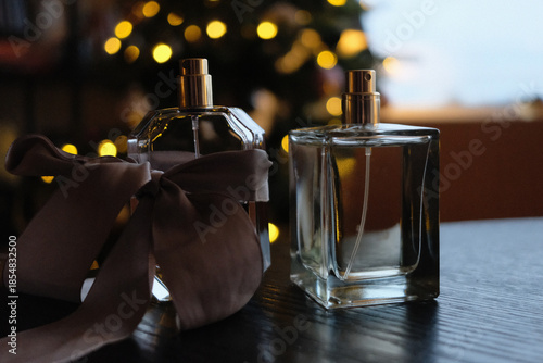 two perfume bottles by a Christmas tree
