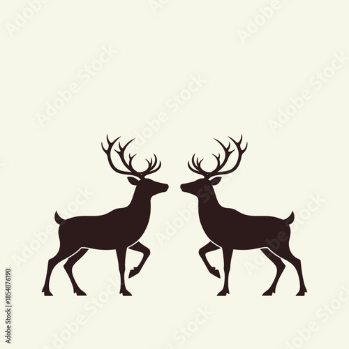 Two majestic reindeer facing each other with a snowflake above artful silhouette