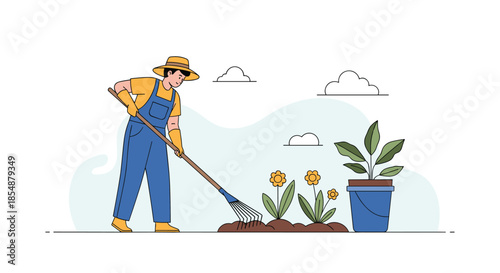 Female gardener in overalls and a straw hat using a rake to cultivate the soil in her flower garden on a sunny day with clouds.
