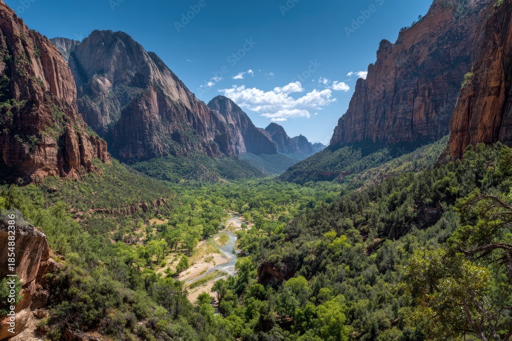 Fototapeta premium Dramatic Zion Canyon Vista - Virgin River Flows Through Lush Valley Framed by Towering Sandstone Cliffs Under Blue Sky.