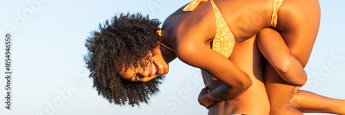 Foto Multiracial happy Boyfriend piggybacking girlfriend on beach in summer – multi e