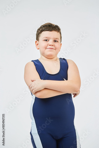 The boy is engaged in wrestling sports, dressed in a sports uniform. White background