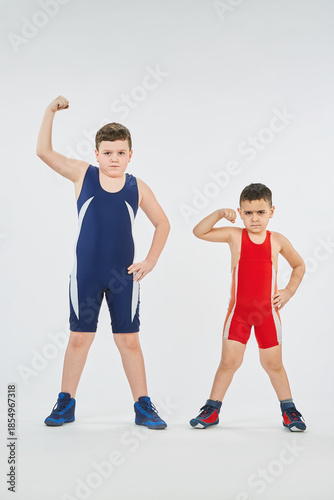 Two boys of different ages are engaged in wrestling sports. White background