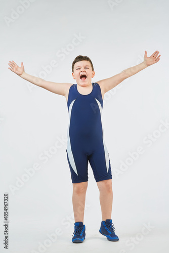 The boy is engaged in wrestling sports, dressed in a sports uniform. White background