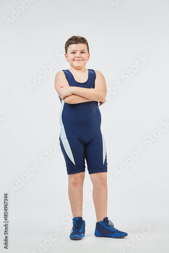 The boy is engaged in wrestling sports, dressed in a sports uniform. White background