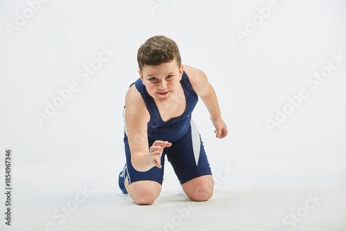 The boy is engaged in wrestling sports, dressed in a sports uniform. White background