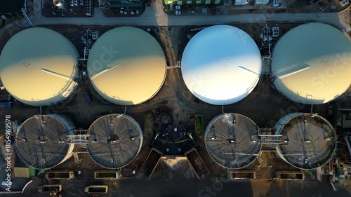 Aerial drone footage of huge Biogas power plant, anaerobic digestion producing electricity from biological waste, domes  and energy infrastructure. Golden sunset in Lincolnshire, United Kingdom. 
