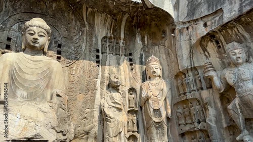 Statues of Vairocana Buddha modeled after Empress Wu Zetian, disciples, Bodhisattvas, Heavenly Kings, Warriors in Fengxian Temple Cave at Longmen Grottoes, Luoyang, Henan, China. UNESCO World Heritage
