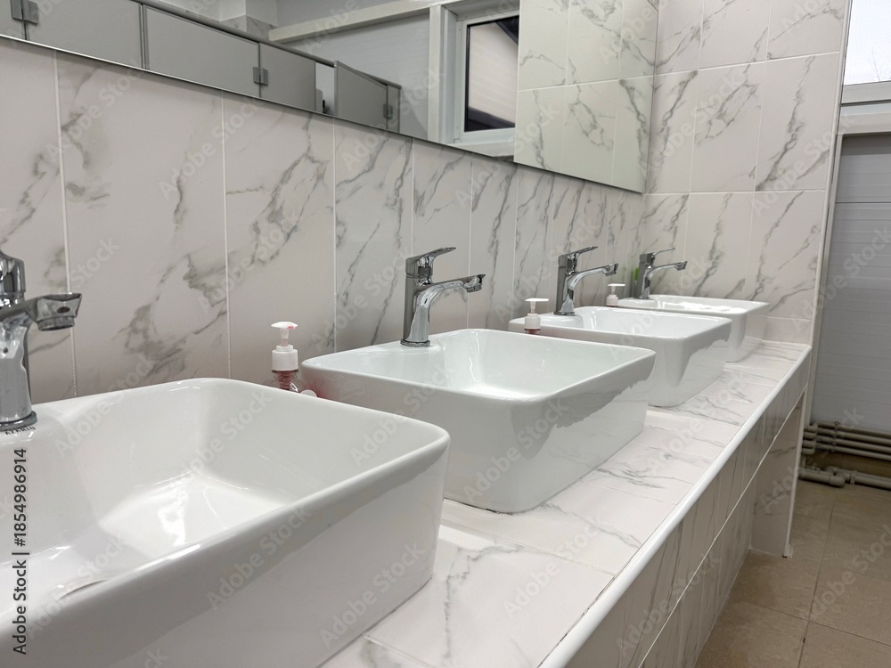 Fototapeta premium Modern Bathroom Sink with Marble Tiles Close-Up
