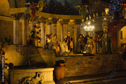 Roma , Italia , San Peter Square 12-18-2025. Nighttime Nativity Scene With Starry Arch, Festive Market Square, And Large Christmas Tree