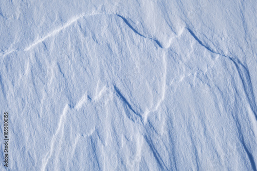 Natural snow background with drawings of mountains made by the wind