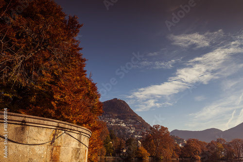 Εκτύπωση καμβά Trees with bright autumn colors on the Lugano lakefront at the entrance to Parco Ciani, Ticino, Switzerland