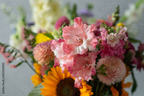 Vibrant floral bouquet featuring pink gladiolus and sunflowers
