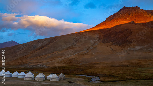 Photography A traditional Yurt camp in the mountains of Kyrgyzstan with beautiful orange sky