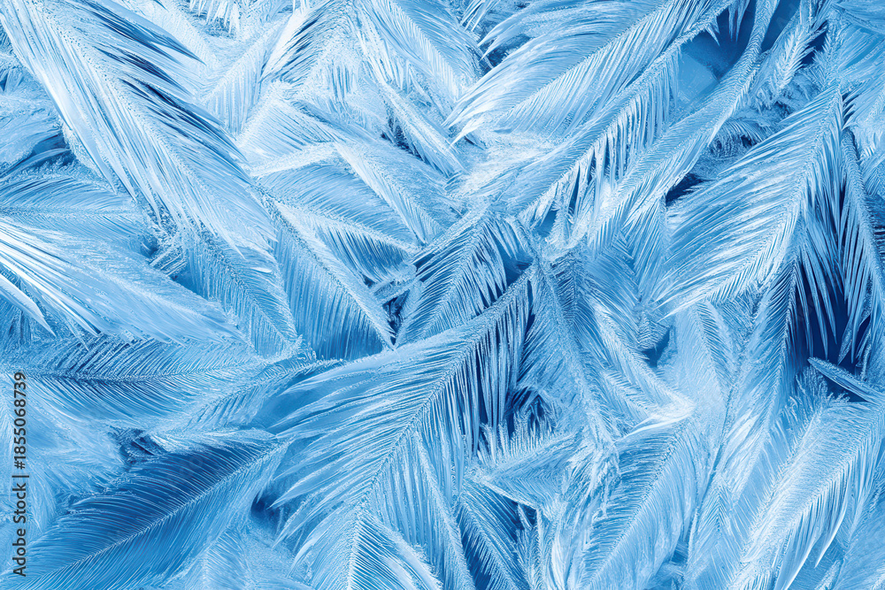 Obraz premium blue frost crystals blooming in fernlike elegance on chilled glass pane serene winter abstraction for desktop wallpaper or banner copy space