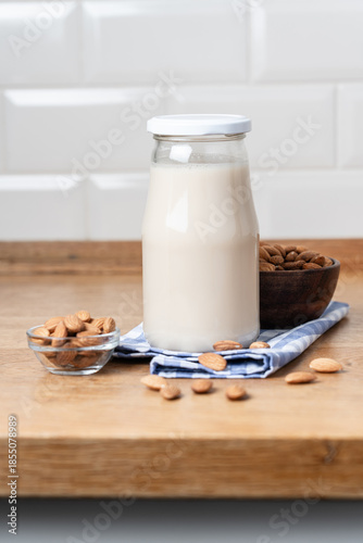 Vegan Almond Milk in Glass Bottle on Wooden Countertop, Healthy Plant Based Nutrition Concept