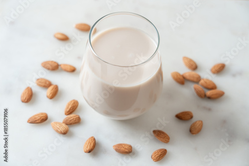 Vegan Almond Milk in Glass on Light Marble Countertop, Top View, Healthy Nutrition Concept