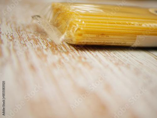 Wallpaper Mural Packaged dry spaghetti lying on rustic wooden surface showing unopened pasta texture and product details for cooking themes, ingredient presentations, and clean food branding, pro photo Torontodigital.ca