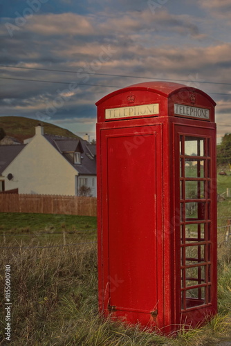 Red telephone booth next to the A855 road in Brogaig village at the foot of the Quiraing landform, old K6 model still operational. Skye-Scotland-180